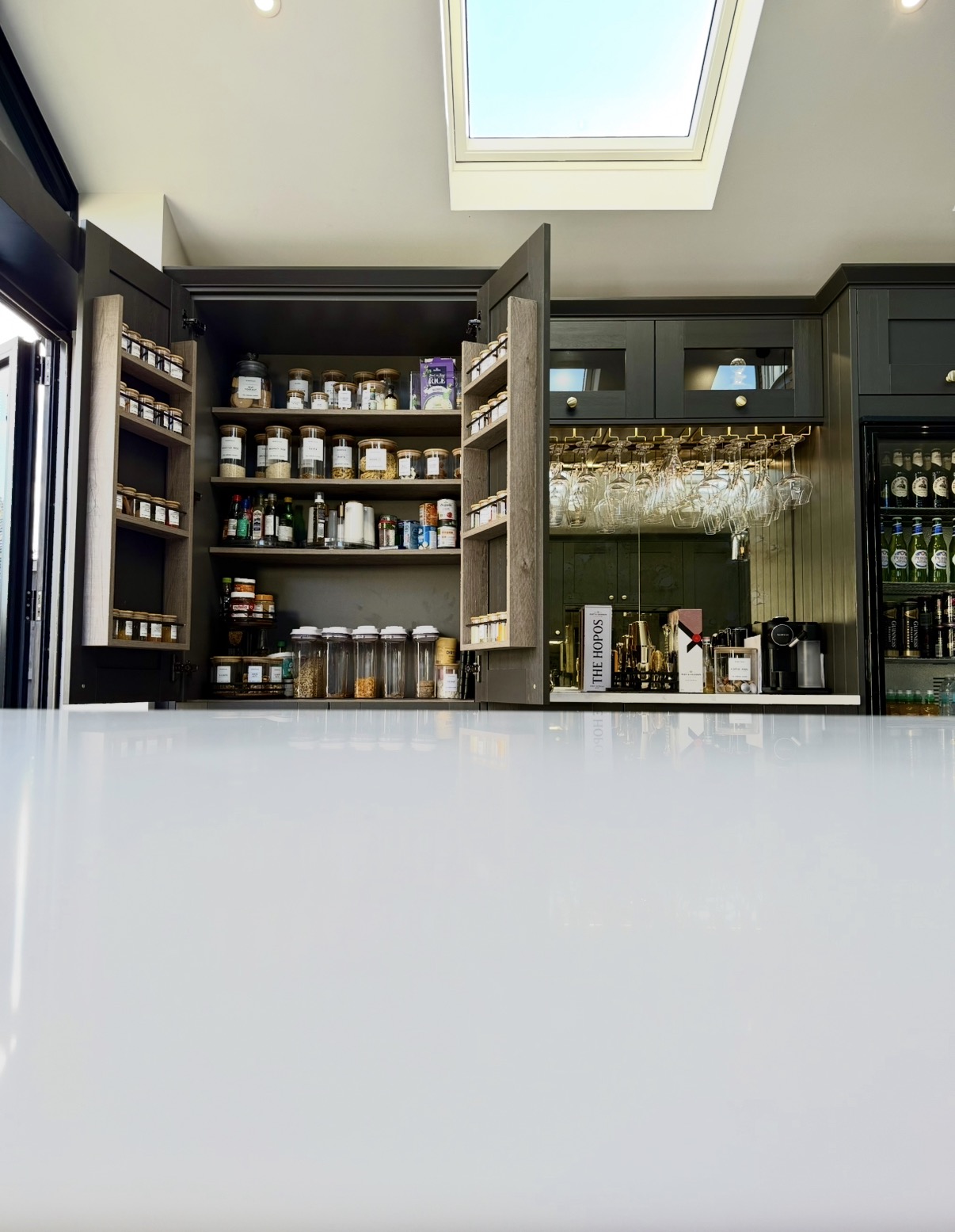 Bespoke dark green kitchen pantry and bar area with integrated storage by RBT Carpentry